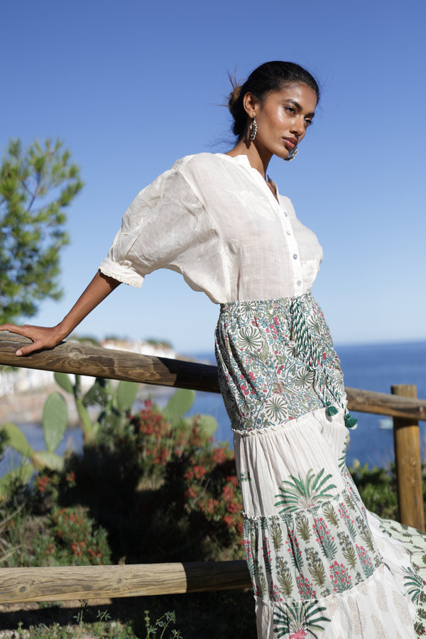  La falda Penélope destaca con un estampado encantador en tonos kaki y naturales, mientras que la blusa Eloisa presenta sutiles detalles en su tejido ligero.