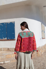 detalle de espalda de la chaqueta de algodon en tonos rojo , anaranjado y aqua. con manga larga y cuello redodno