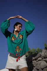 bluson de algodon en color verde y bordado a contraste de piñas. tiene manga largas amplias y holgadas y acabada con elastico en puño
