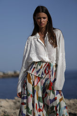 parte frontal del conjunyo formado por la blusa blanca con bordados a tono y falda pantalon estampada