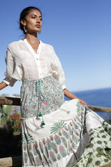 La falda Penélope irradia estilo con un estampado floral en tonos kaki y naturales. La cintura elástica y los detalles lúdicos de cintas y pompones 
