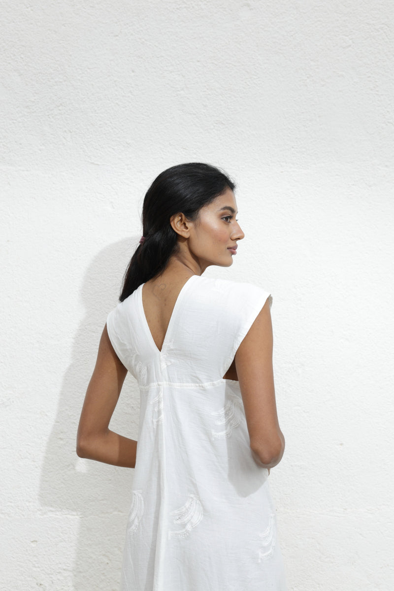La espalda del vestido blanco Hermione: simple, elegante, con un sutil escote en V que realza tu figura.